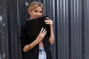 young office worker woman with weekly planner on gray wall background