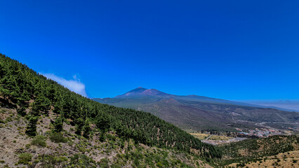 Scenic view on volcano Pico del Teide surrounded by Canarian pine tree forest, Teno mountain range, Tenerife, Canary Islands, Spain, Europe. Hiking trail from Santiago to Masca village via Pico Verde