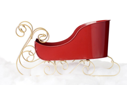 closeup metal santa sleigh with gold runners on snow