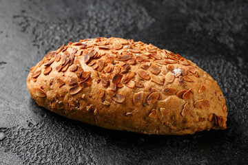 Fresh Homemade bloomer bread with almond flakes on rustic dark background