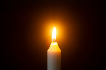 white burning candle on a black background