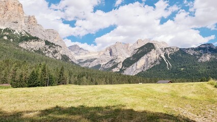 Val Badia, Italy-July 18, 2022: The italian Dolomites behind the small village of Corvara in summer days with beaitiful blue sky in the background. Green nature in the middle of the rocks.