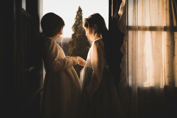 Little girls in white vintage dresses inside a countryside cabin