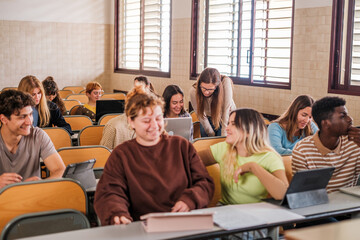 Group of students assisted by the teacher who explains them individually - focus on the teacher