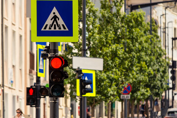 Traffic and pedestrian semaphores with red lights to stop them crossing the road in an urban area