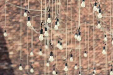 Many light bulbs hanging outside over a yard during an outdoor event