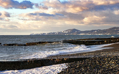 An old breakwater in seaweed on the background of a sea sunset in Adler