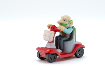 Grandfather on motorized wheelchair, toys, white background, cropped image
