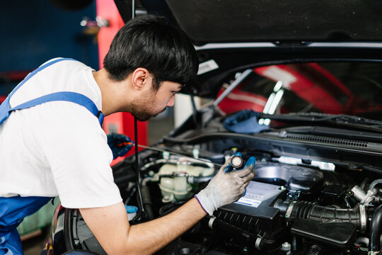 Car Service Center and Automobile Maintenance, Auto mechanic is diagnosing the cause of an engine problem that needs to be fixed at the shop