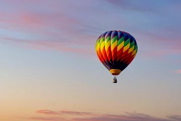 Foto op Canvas Beautiful view of colorful hot air balloon flying high under sunset sky with clouds © Christopher Hand/Wirestock Creators