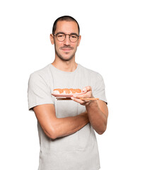 Young man using chopsticks to eat sushi