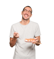 Young man using chopsticks to eat sushi