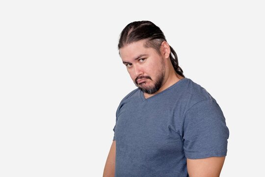 A man in his 30s with hurt feelings sulking. Let down by someone or feeling sorry. Looking a bit funny. Isolated on a white background.