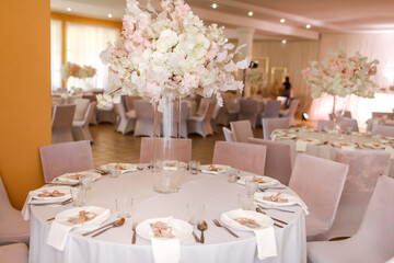 festive wedding decoration. Beautiful fresh white and pink flowers in glass vase on dining table on wedding day. High quality photo