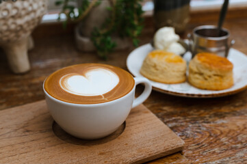 Hot coffee in white cup on wooden tray. Copy space.