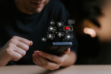 Man using smart phone with notification icons of love, like, message, comment, email, address, shopping and star above smartphone screen, Social, media, Marketing concept.