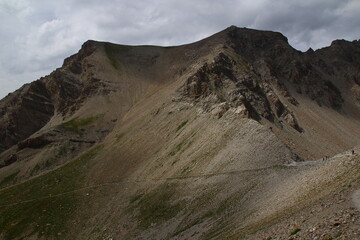 Four hikers leave the col de la petite Cayolle by a narrow path (Parc du Mercantour, Haut Verdon, Alpes-de-Haute-Provence, France)