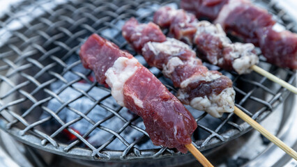 Top view flat lay Raw beef steak with herbs cooks on the grill, Roasting raw fresh beef steak with herbs above burning grill grid, Barbecue and grill concept.