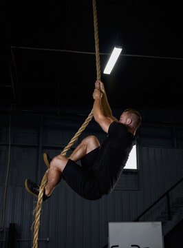 Man Climbing A Rope In The Gym