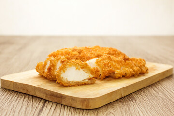 Sliced fried chicken on wooden butcher table