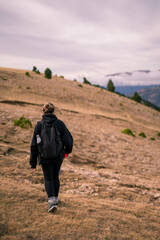 blonde woman from behind hiking at the forest in autumn