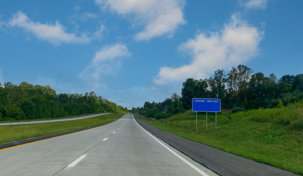 Virginia highway in summer with LODGING exit sign.