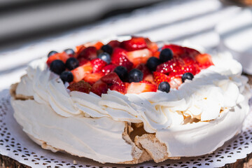 meringue pavlova cake with chantilly cream and red berries