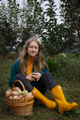 girl holds  basket  with juicy apples in the garden
