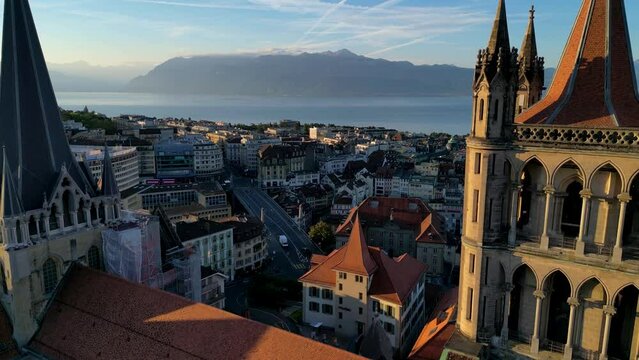 August 22nd 2022, Lausanne, Switzerland. A drone aerial footage of Lausanne cathedral, the city, and Lake Geneva at sunrise.