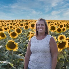 Woman Standing in Large Sunflower Field in Kansas