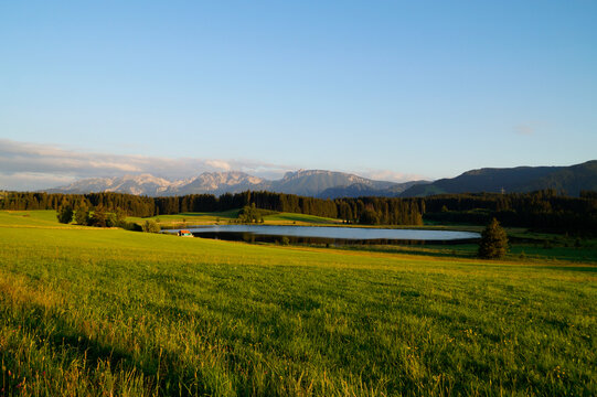hiking trail overlooking scenic alpine lake Attlesee and the lush alpine valley with its endless green alpine meadows in the Bavarian Alps in Nesselwang, Allgaeu or Allgau, Bavaria, Germany