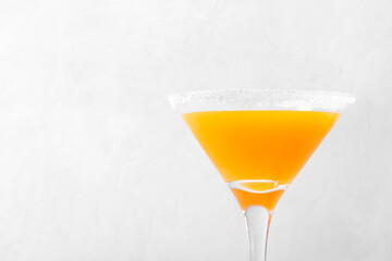 Yellow alcoholic cocktail with fruit juice served in martini glass decorated with sugar border. Copy space - 529855666