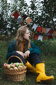 girl holds  basket  with juicy apples in the garden