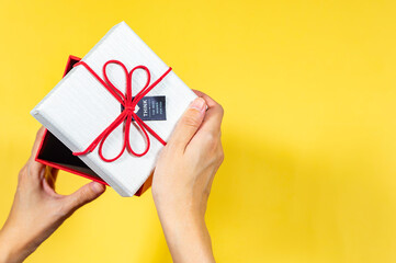 Hand open a present gift box on yellow background, Top view, Copy space, Holiday and present concept