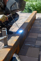 A worker works with metal welding at a construction site.