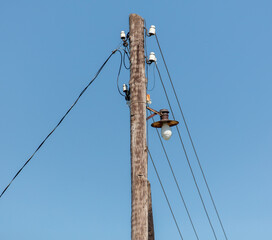 Old wooden electric pole against the sky.