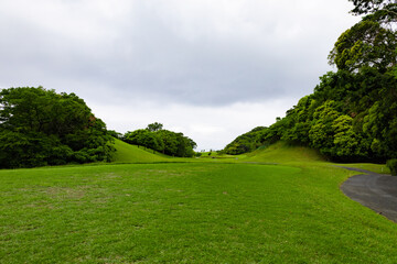 Fototapeta na wymiar 曇り空のゴルフ場・奥に海が見える高台からの打ちおろしコースのティーグラウンド（千葉県富津市） 