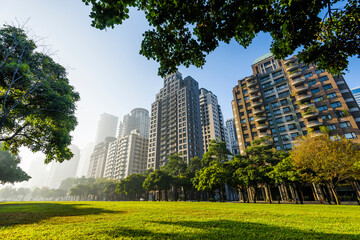 Low angle view of park green space and modern buildings on both sides in downtown Taichung, Taiwan. here is near the National Taichung Theater.