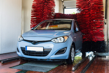 Car washing machine. Auto brush washer clean blue car on automatic carwash station. Automated car...