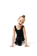 Charming little gymnast girl posing at studio