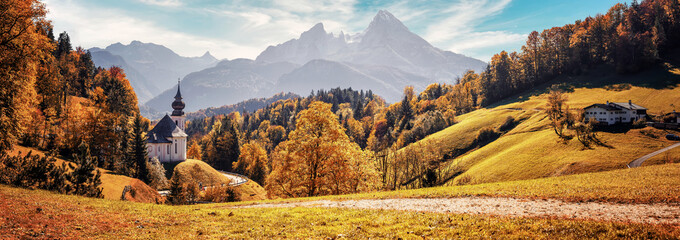 Stunning Autumn landscape. Scenic view on Maria Gern church with mountains on background. Vivid...