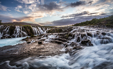 Fototapeta na wymiar Fantastic Bruarfoss Waterfall. Amazing nature of Iceland. Iceland popular place of travel and touristic location. Wonderful Icelandik landscape during sunset. Creative image. Natural background