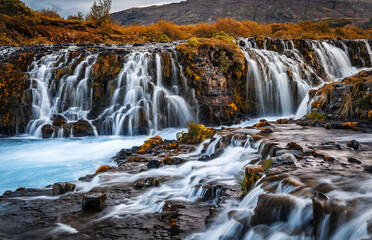 Fototapeta premium Fantastic Bruarfoss Waterfall. Amazing nature of Iceland. Iceland popular place of travel and touristic location. Wonderful Icelandik landscape during sunset. Creative image. Natural background