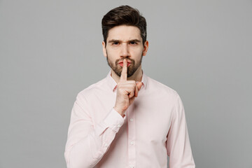 Young fun secret caucasian man 20s he wearing basic white shirt saying hush be quiet with finger on...