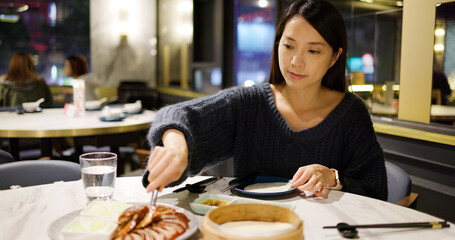 Woman enjoy her dinner with roasted duck in restaurant