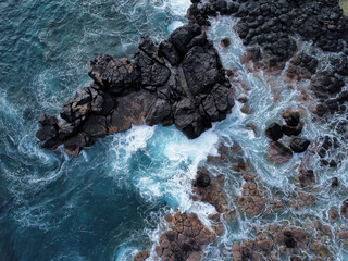 Obraz premium Drone shot of waves crashing on rocks in Mauritius