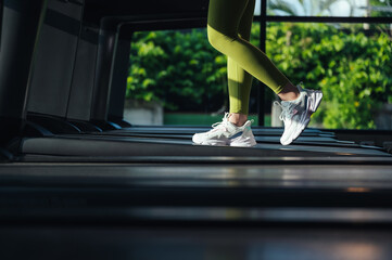 Selective focus, Sport woman foot in shoe sportswear cardio exercise walking or running on a treadmill in fitness gym. Sport girl workout for building a beautiful slim body.