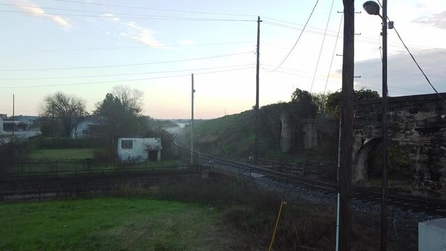 Crane shot over mist covered train tracks at sunrise in rural Macon Georgia