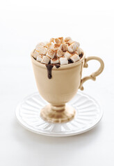 Cup of hot chocolate with marshmallow and cinnamon on the white table. Tradition winter sweet drink.