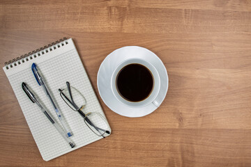 Coffee mug and notepad, workplace concept, top view